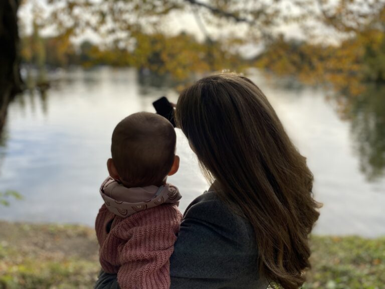 Mutter macht ein Selfie mit ihrer Tochter. Der See ist dabei im Hintergrund.